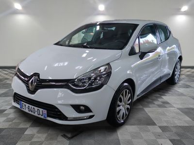 la voiture blanche est garée sur un sol en damier dans le garage