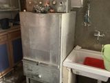 une photo d'une cuisine sale avec une cuisinière et un évier