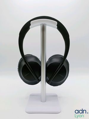 the headphones are sitting on a stand on a white surface