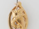 an image of a gold plated pendant with a bird on it