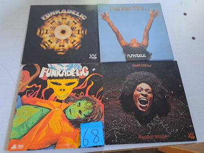 plusieurs pochettes d'albums différentes posées sur une table sur laquelle est collé un autocollant bleu