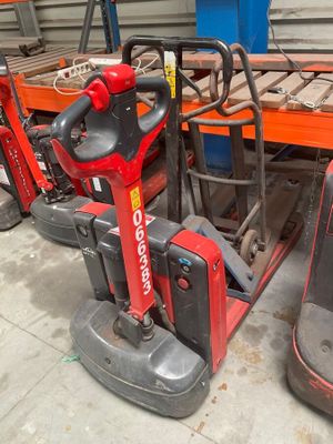 two red and black forklifts sitting next to each other in a warehouse