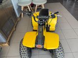 a yellow four wheeler motorcycle parked in a room