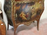 a picture of a painting on a chest of drawers next to a chair