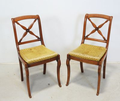 deux chaises en bois aux assises rembourrées de jaune, adossées à un mur blanc