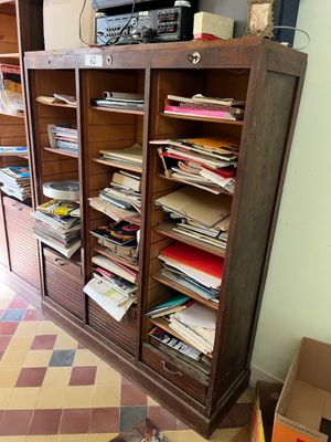 a wooden cabinet with many files on it in a room