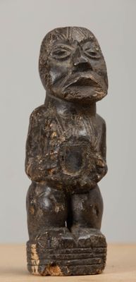 an old wooden statue of a man holding a baby on top of a wooden table