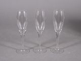 three empty wine glasses are lined up on a gray surface