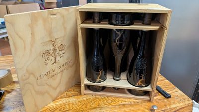 bottles of wine in a wooden box on a wooden table