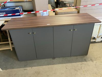 a wooden counter with two doors on it in a room