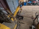 a yellow bulldozer sitting inside of a garage