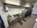 une grande cuisine équipée d'appareils électroménagers en inox et d'un évier