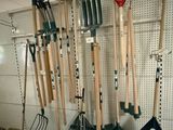 many different types of garden tools hanging on the wall