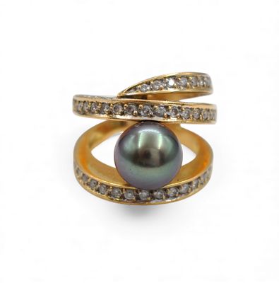 a close up of a ring with a black pearl and diamonds