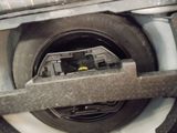 a close up of a car ' s front wheel with a yellow button