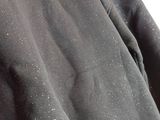 the back of a black hoodie with white speckles on it