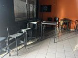 des tables et des chaises dans une pièce aux murs orange et au sol carrelé de blanc