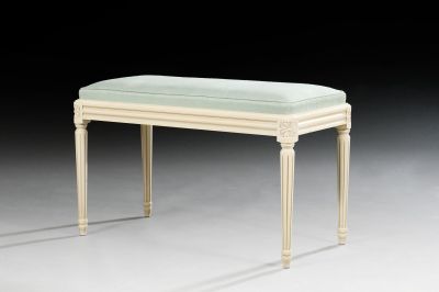 a white bench with a green cushion on top of it