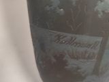 a vase with a painting on it sitting on a table
