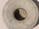 a white vase with a hole in the middle of it
