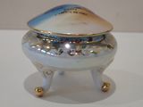 a small blue and white bowl with a lid on a stand