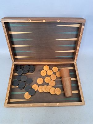 an image of a wooden backgamrd with coins and a roll of paper