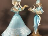 pair of blue glass figurines of ladies with hats and tails
