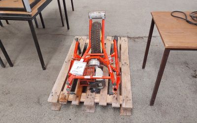 a small motorbike sitting on a pallet in the middle of a room