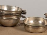five silver cups sitting on top of a wooden table