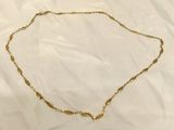 a gold necklace with a chain that has a knot on it