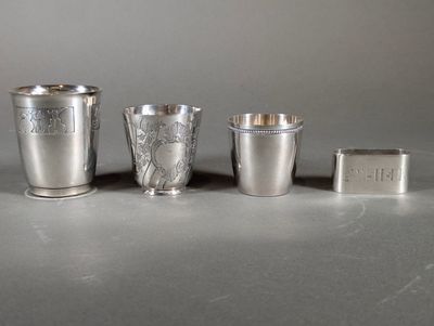 three silver cups and a lighter sitting on a table