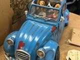 a blue toy car sitting on top of a wooden table