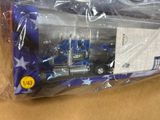 un petit camion-jouet bleu et blanc dans un sac en plastique
