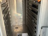 a large metal oven with many trays of food inside of it