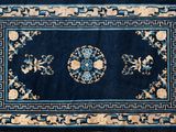 une photo d'un tapis bleu orné d'un motif floral