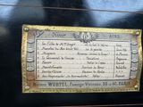 a plaque on the side of a black piano