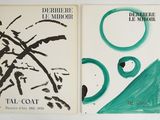 two books on a white table with a green and black cover