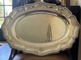 a large silver platter sitting on a chair in front of a window