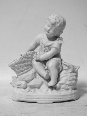photo en noir et blanc représentant la statue d'un garçon avec un panier