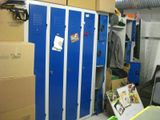 a blue locker in the middle of a room with boxes on the floor