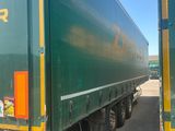 a green semi truck that is parked in a lot