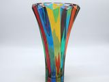 brightly colored glass vase sitting on a white surface with a white background