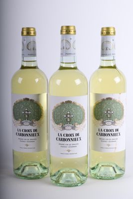 trois bouteilles de vin blanc posées les unes à côté des autres sur une table