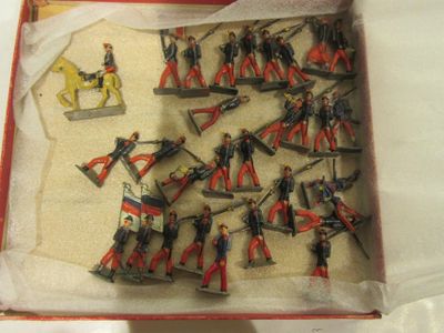 de nombreux petits soldats dans une boîte posée sur une table
