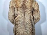 the back of a man ' s fur coat on display in front of a white background