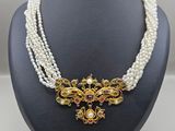 un collier de perles blanches avec un fermoir en or et un collier de perles multicolores