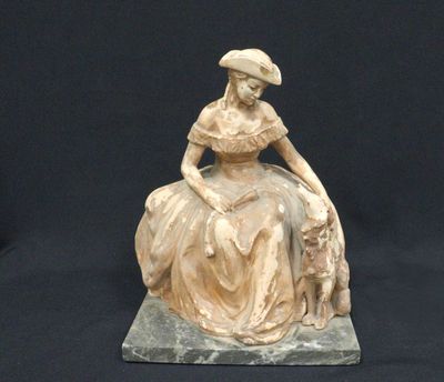 statue of a woman sitting on a rock with a dog