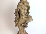 statue of a woman with long hair and a bird on her head