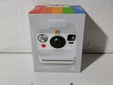 un appareil photo Polaroid dans la boîte posée sur la table