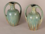 two green vases sitting next to each other on a table